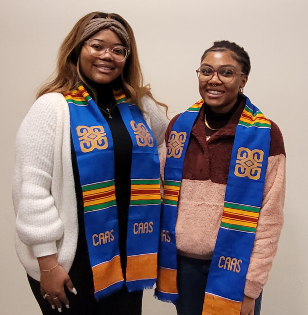 Two young women with graduation stoles